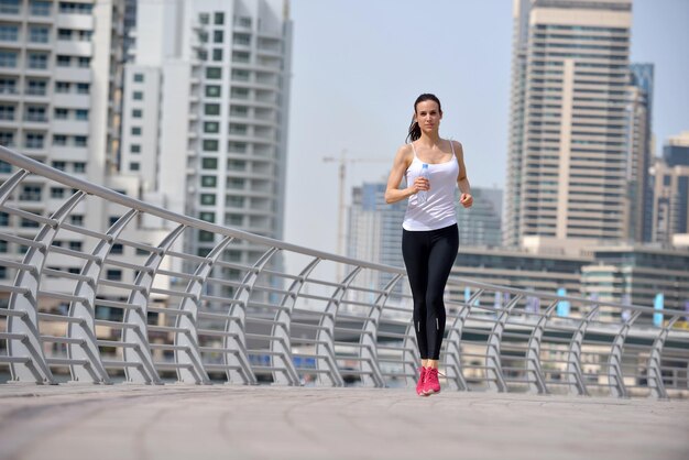 Correndo no parque da cidade. Corredora do lado de fora correndo de manhã com a cena urbana de Dubai ao fundo