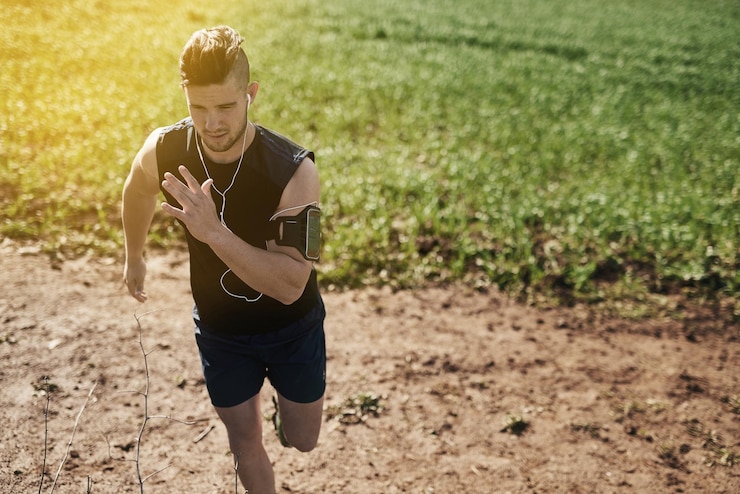 Foto correr al aire libre y hombre con auriculares para música ejercicio físico y entrenamiento para competición deportiva con salud naturaleza escuchar sonido y corredor masculino para entrenamiento con lista de reproducción de audio en línea