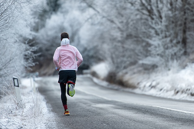 Correr durante el entrenamiento en carretera helada en invierno