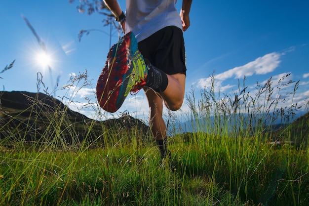 Foto correr en las montañas en el prado con sol y hermosos paisajes naturales