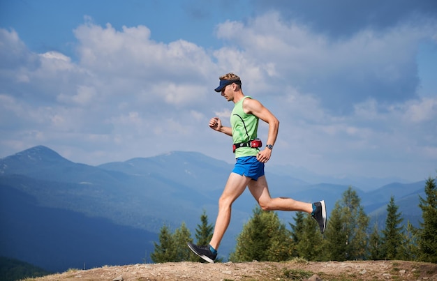 Correr por los senderos cubiertos de hierba de las colinas de las montañas