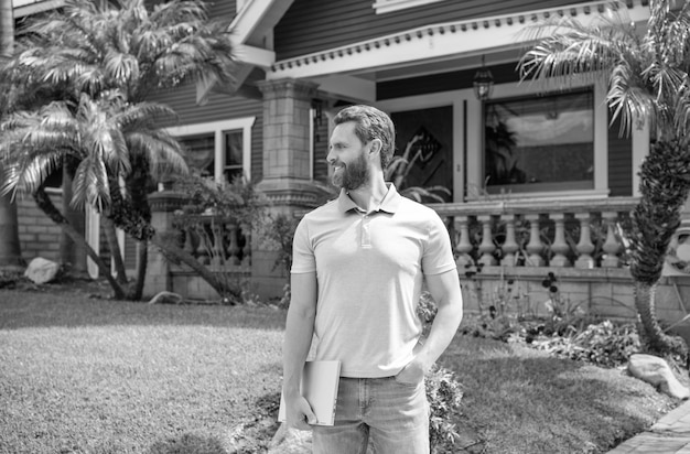 Corretor de homem barbudo feliz vendendo ou alugando casa no avaliador de propriedade on-line do pc