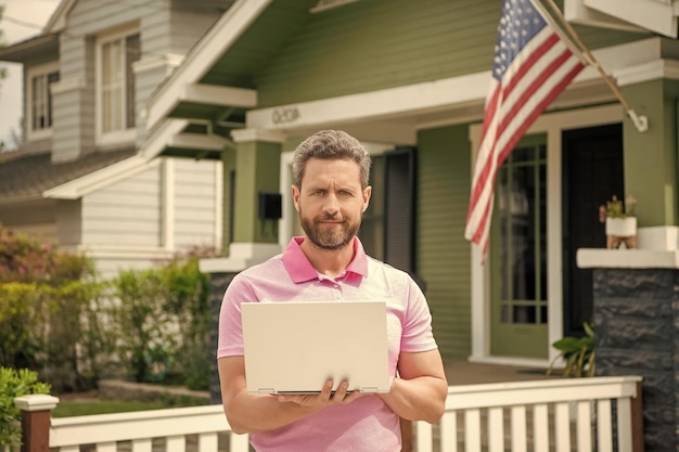 Corretor de homem barbudo vendendo ou alugando casa com bandeira americana no pc online home