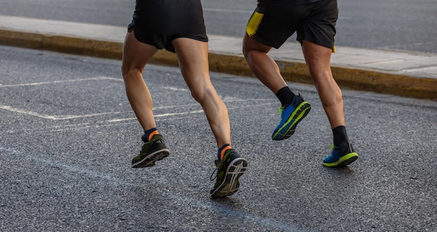 Corrida de corrida de maratona dois corredores em detalhes de estradas da cidade nas pernas