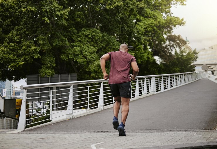 Foto corrida de fitness e homem em uma ponte para treinamento de bem-estar e cardio em uma cidade cardio e energia corredor de esportes e exercícios masculinos em uma estrada para desafio de corrida e metas de desempenho corporal