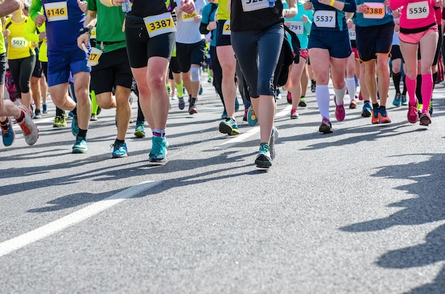 Foto corrida de maratona com muitos pés de corredores em competição esportiva de corrida de rua