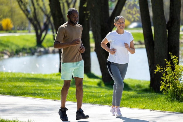 Corrida matinal Homem e mulher a correr juntos no parque