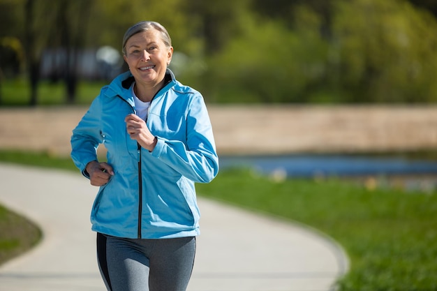 Corriendo en el parque Una mujer madura y guapa corriendo en el Parque y pareciendo contenta