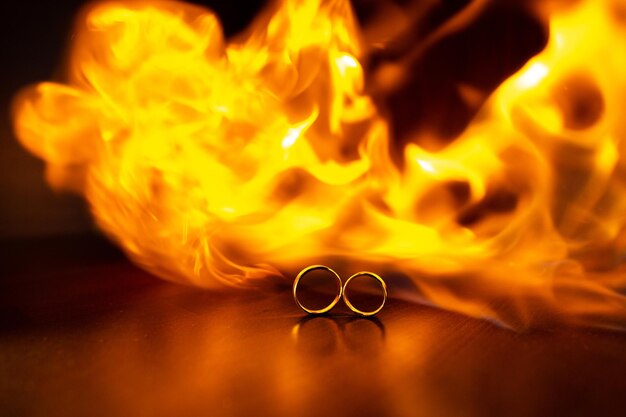 Una corriente de fuego Anillos de boda en llamas con reflejo en el enfoque selectivo negro