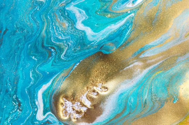 Corrientes de tinta líquida azul blanca y dorada rizan ondas de pintura fluida turquesa y dorada fluida