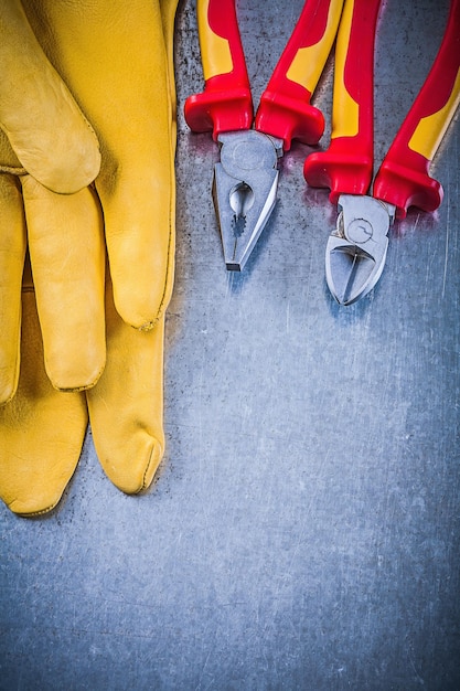 Foto cortador de alambre de alicates de guantes protectores amarillos en backgrou metálico