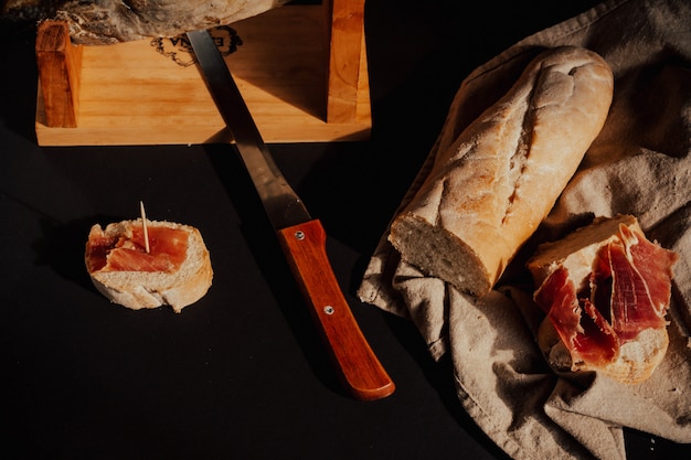 Cortando Jamón Ibérico con pan, madera, cuchillo.