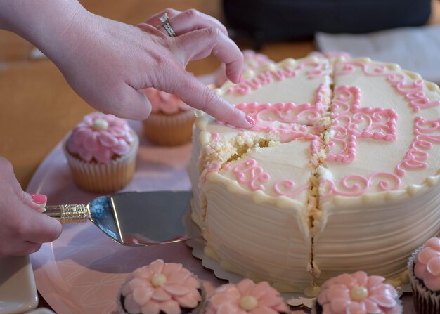 Foto cortando o bolo na festa de batizado do bebê
