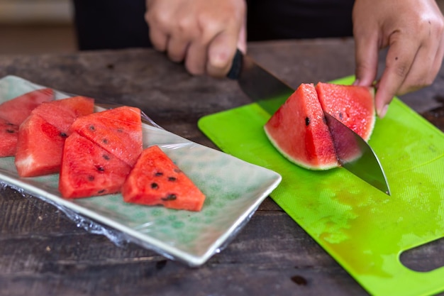 Foto cortar a melancia em um invólucro de prato lindamente organizado e selar em plástico transparente