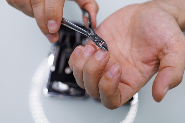 Foto cortar a unha com uma tesoura de manicure profissional um homem faz-se uma manicure