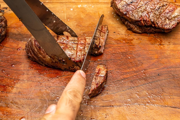 cortar bistec picanha sobre tabla de cortar, carne de res en la fiesta de barbacoa