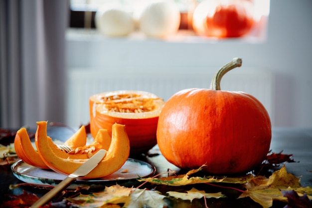 Cortar la calabaza en un plato con cubiertos sobre la mesa