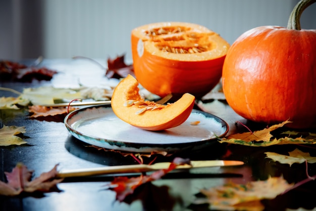 Cortar la calabaza en un plato con cubiertos sobre la mesa