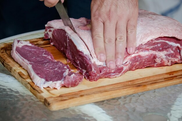 Cortar carne en la mesa con un cuchillo afilado con fondo paisajístico