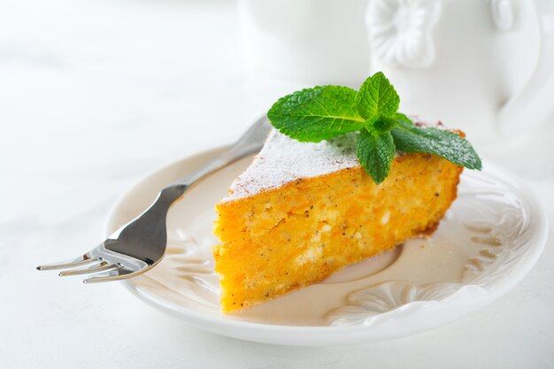 Cortar la cazuela de queso con calabaza y canela para el desayuno en un plato de cerámica sobre una mesa de luz. Enfoque selectivo.