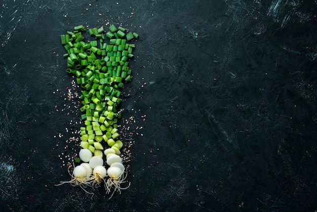 Cortar cebollas verdes en una mesa de madera Verduras frescas Vista superior Espacio libre para texto