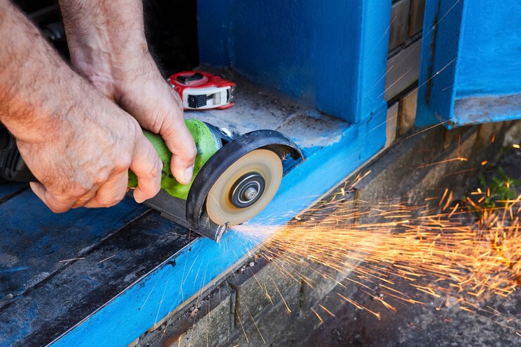 Foto cortar una esquina de metal con una sierra circular con salpicaduras de chispas. trabajos de jardinería