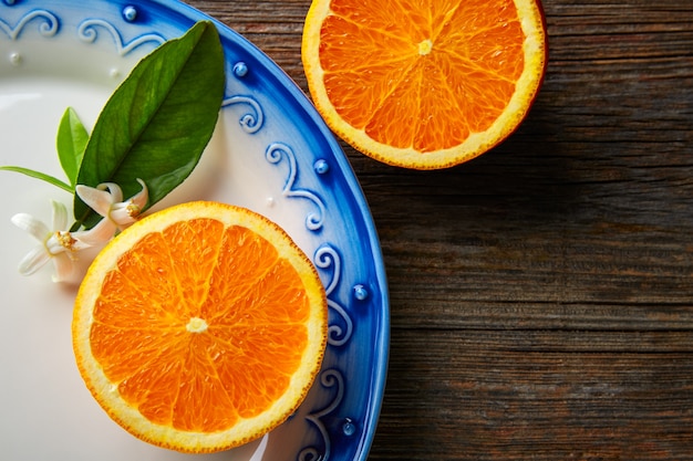 Cortar fruta de naranja abierta con flor de naranja.