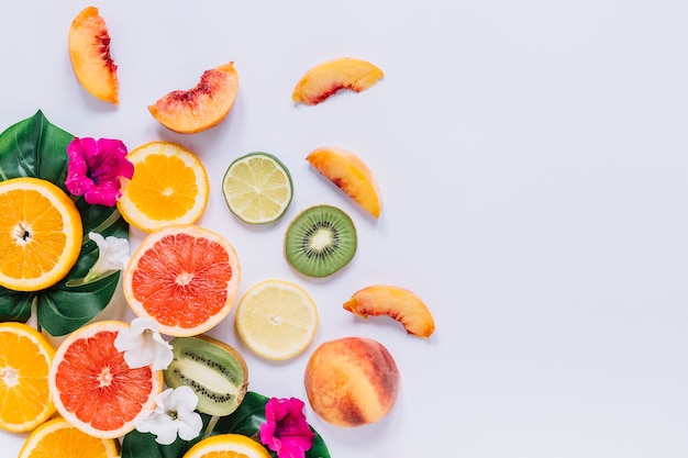 Foto cortar frutas cerca de hojas y flores