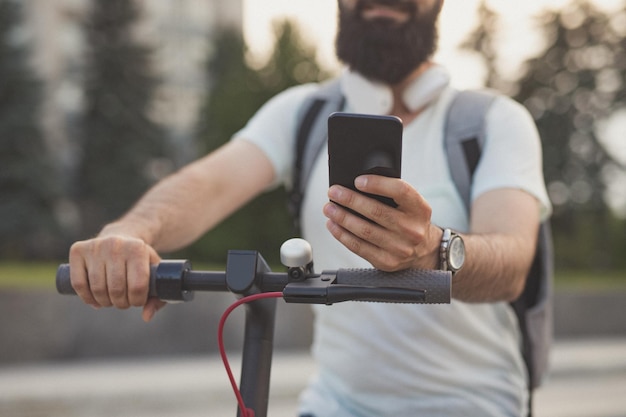 Cortar hipster usando smartphone na scooter