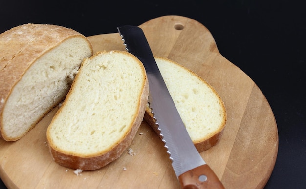 Cortar la hogaza de pan con un cuchillo en la tabla de cortar