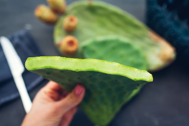 Cortar las hojas de cactus con tuna o fruta de cactus. Comida sana exótica en gris. Vista superior