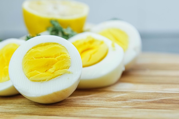 cortar huevos cocidos en una tabla de madera en la cocina