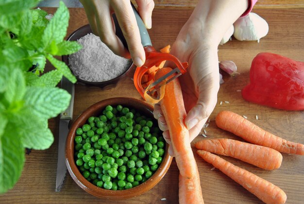 Cortar a mano varios tipos de vegetales para cocinar.