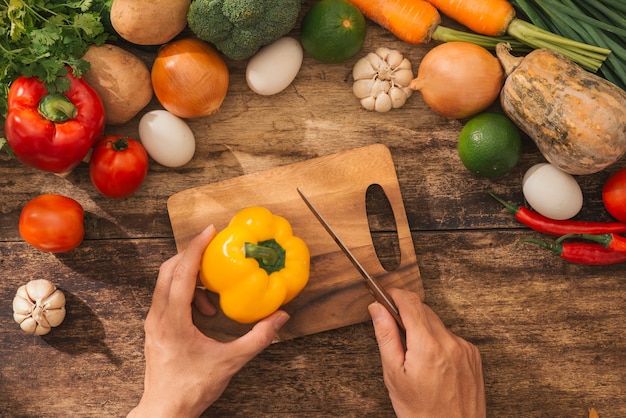 Cortar las manos de cocinero hombre macho preparación de cuchillo ensalada de verduras frescas en la cocina