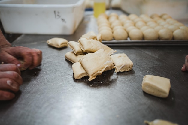Cortar la masa de pan lista para ser amasada en bolas en la cocina de una panadería