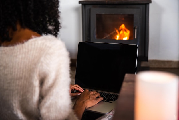 Cortar mulher negra trabalhando no laptop