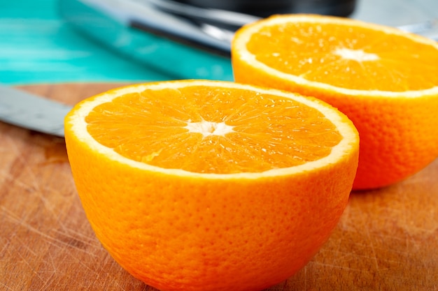 Cortar las naranjas en la tabla de madera en la mesa