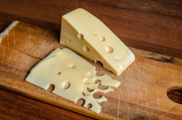 Cortar o queijo em uma placa de madeira.