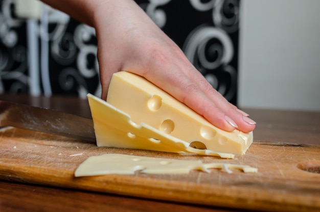 Cortar o queijo em uma placa de madeira.