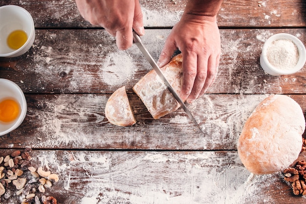 Cortar pan casero en la mesa de la cocina