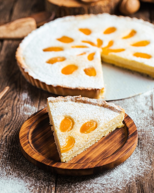 Cortar un pedazo de pastel de dulce y delicioso pastel de cuajada de albaricoque