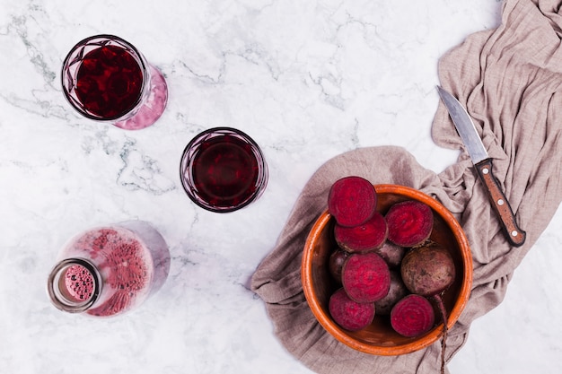 Foto cortar la remolacha con vasos de jugo.