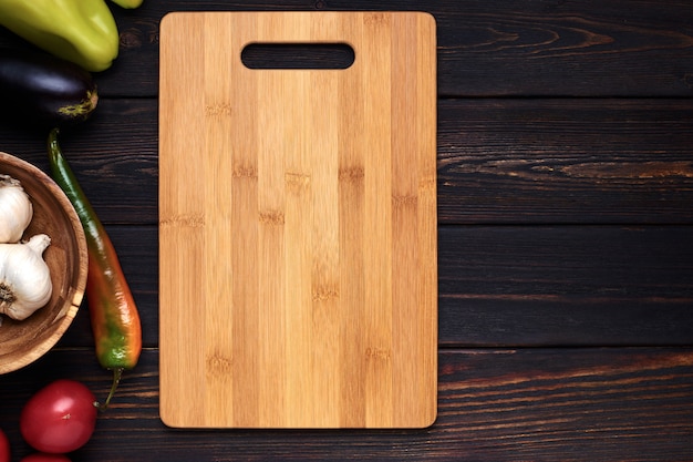 Cortar la tabla de madera en la mesa de la cocina de madera