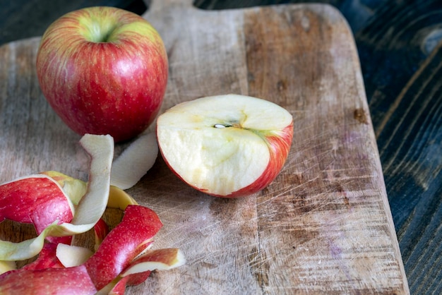 Cortar una tabla vieja con trozos de manzana roja madura