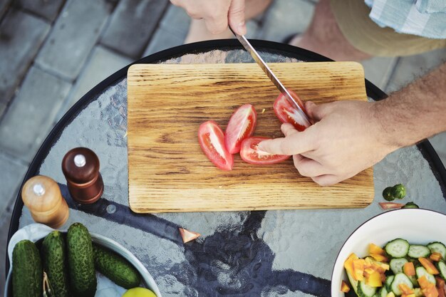 Foto cortar tomates para una ensalada de verduras