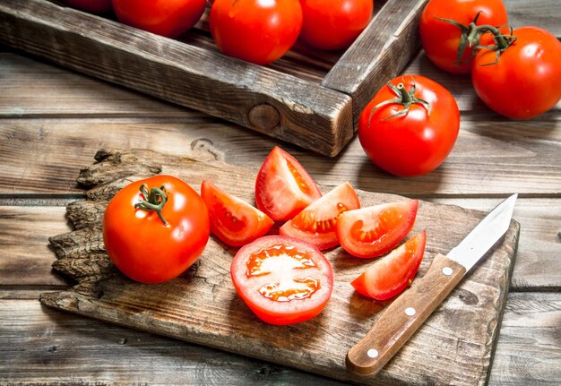 Cortar los tomates en una tabla de cortar con un cuchillo