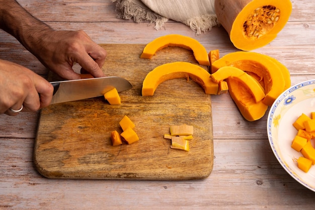 Cortar trozos de calabaza en una tabla de cortar