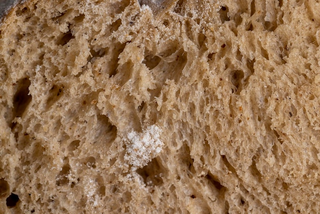 Cortar en trozos una hogaza de pan oscuro recién horneado una hogaza de pan suave de harina de trigo fresco con levadura
