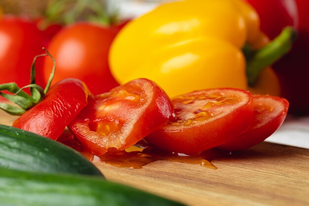 Cortar trozos de tomate sobre tabla de madera de cerca