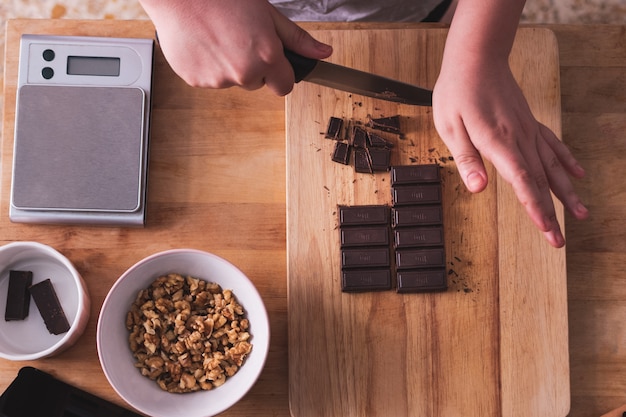 corte a barra de chocolate em uma placa de madeira